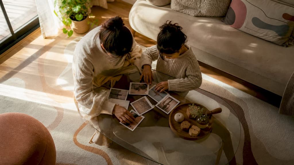Des mains qui disposent soigneusement des photos de famille sur la table
